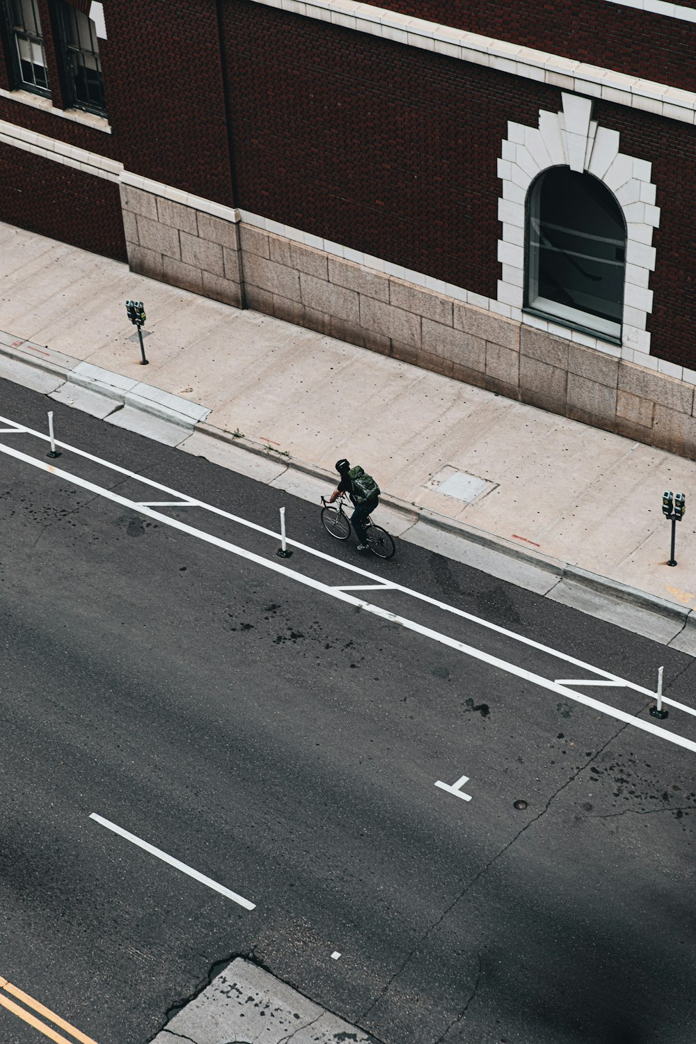 man in black jacket and black pants walking on gray asphalt road during daytime