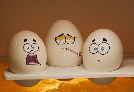 2 white and black ceramic egg figurines