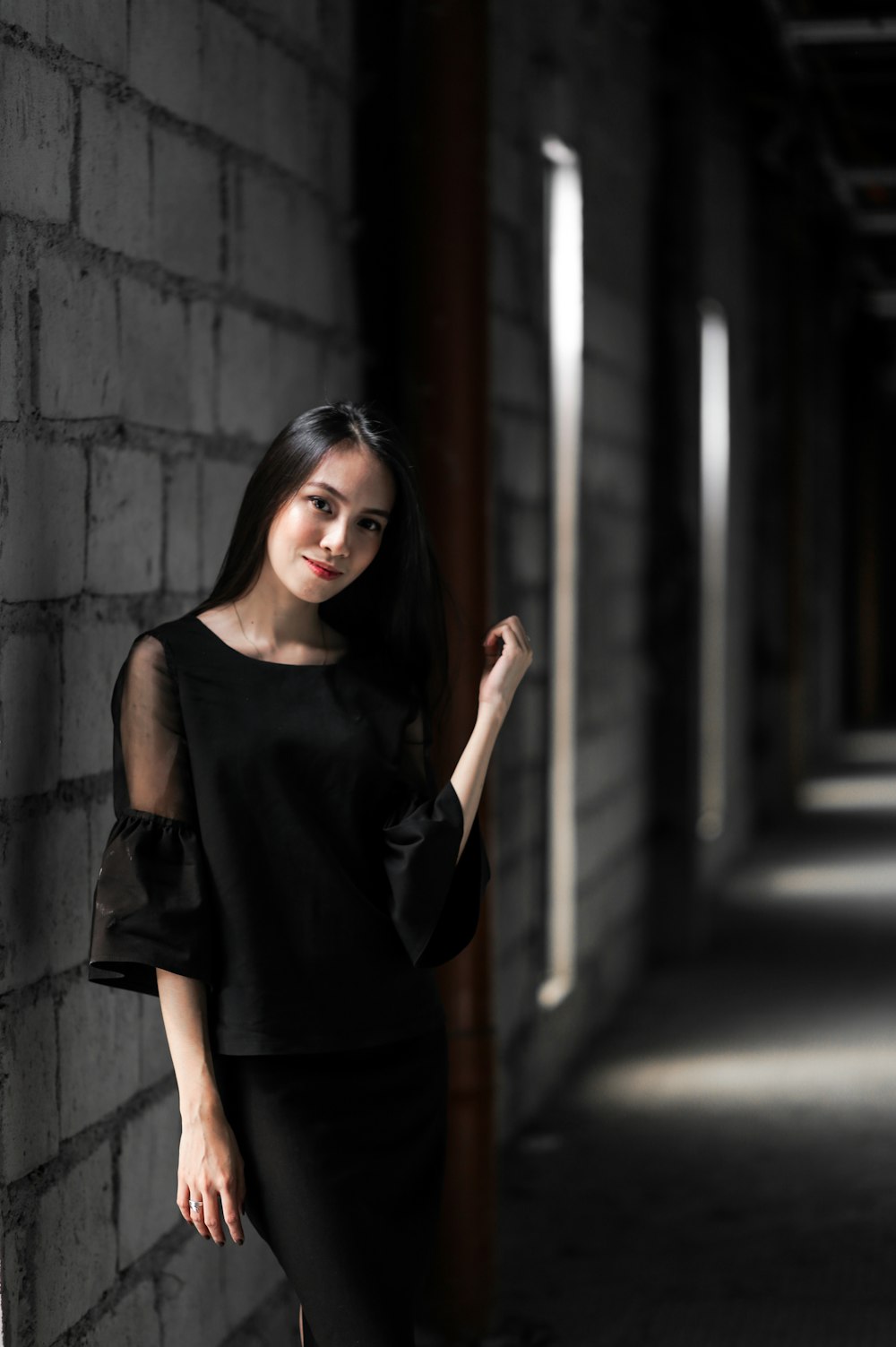 woman in black tank top standing beside wall