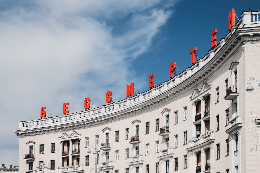 Weiß-rotes Betongebäude tagsüber unter bewölktem Himmel