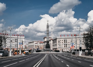 white and brown concrete building under white clouds and blue sky during daytime