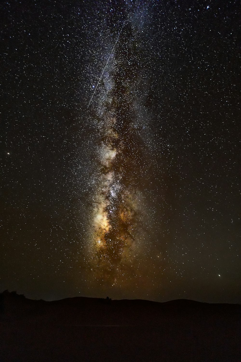 silhouette of mountain under starry night