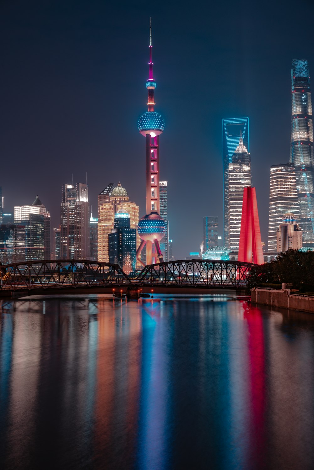 city skyline across body of water during night time