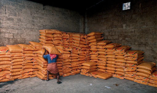 person in blue shirt and black pants sitting on brown wooden chair
