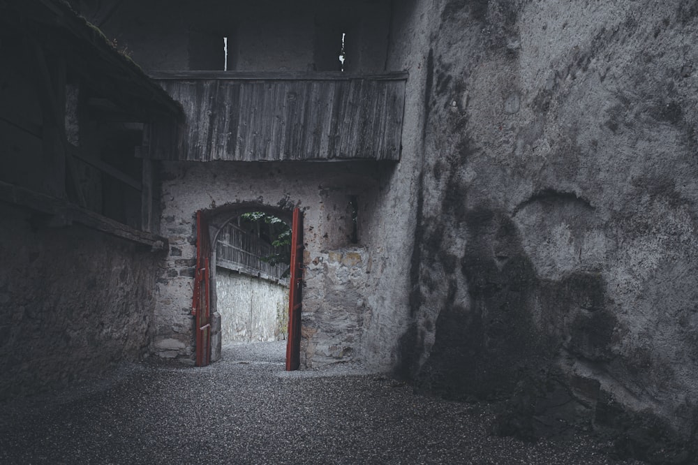 scala in metallo rosso appoggiata a un muro di cemento grigio