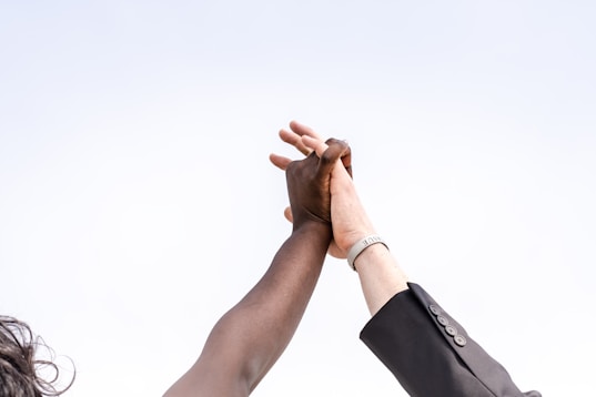 Two people clasping hands and celebrating victory