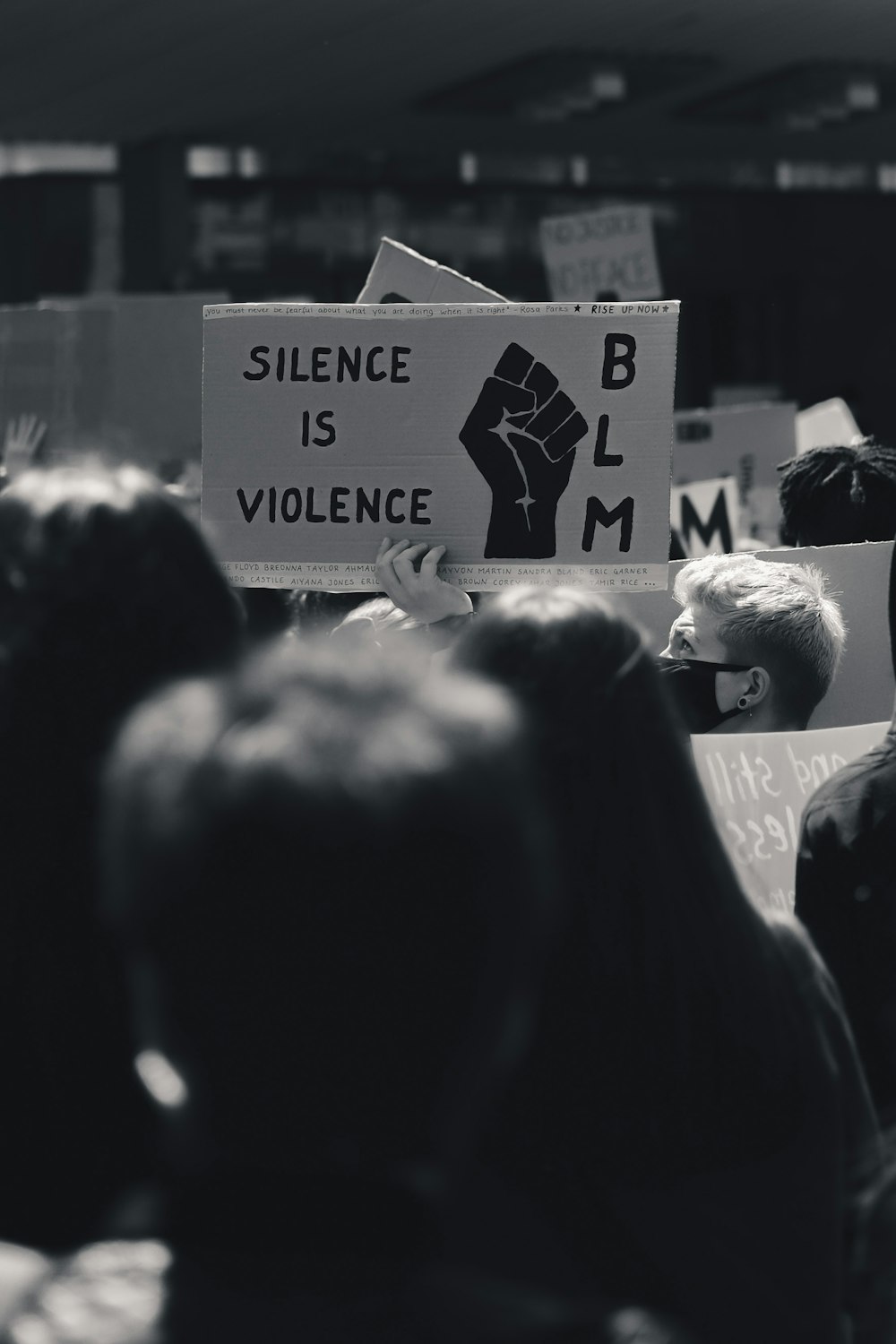 grayscale photo of people holding a signage