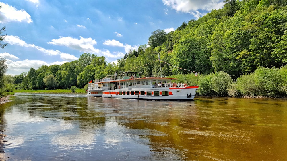 Barco rojo y blanco en el río durante el día