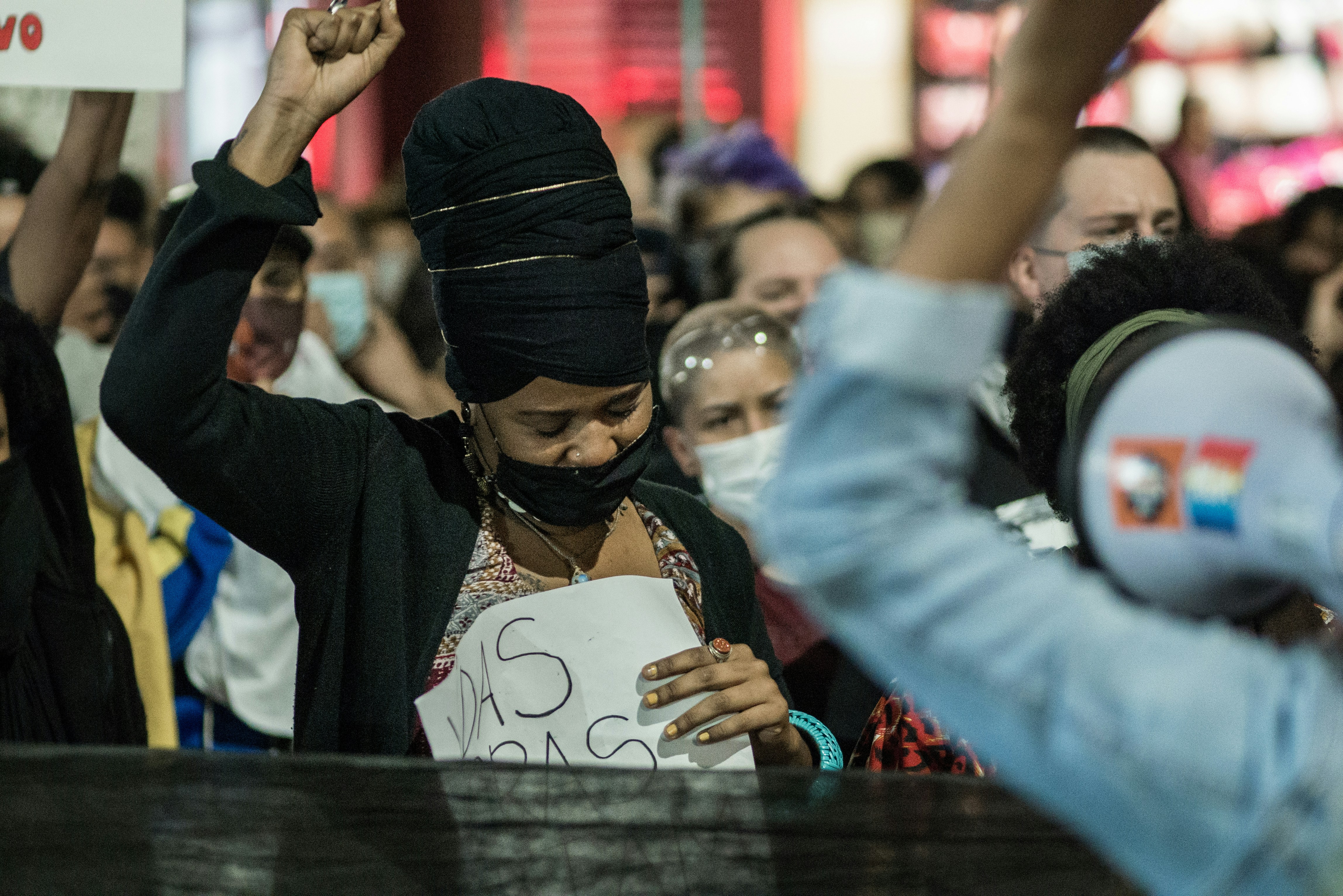 woman in black hijab holding white paper