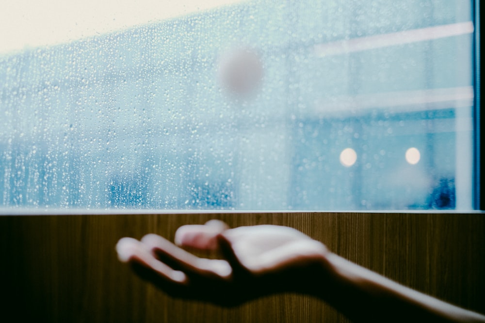 persons hand on glass window