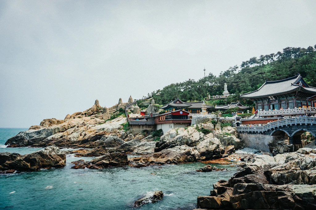 Haedong Yonggungsa temple buildings and a stone bridge on the rocky shore outside Busan