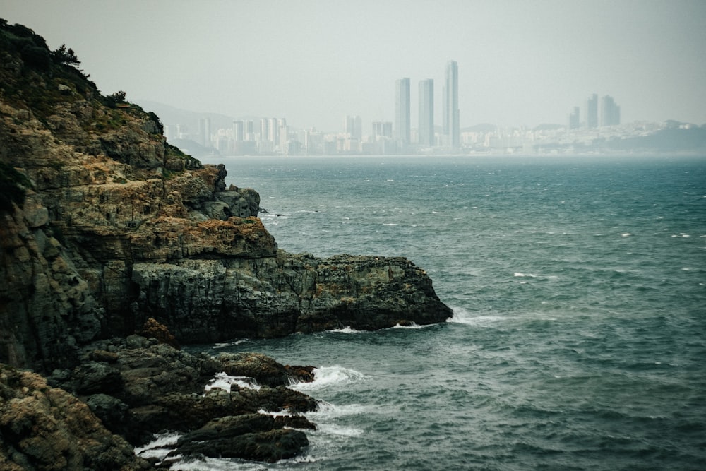 high rise building on rock formation near sea during daytime