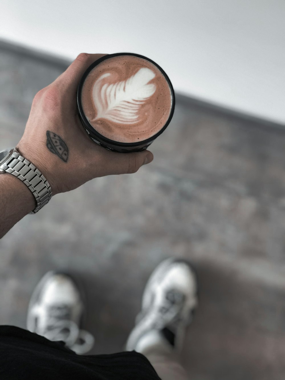 person holding brown ceramic mug with brown liquid