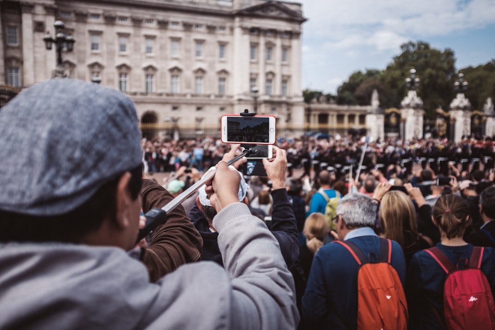 Gente tomando foto de un edificio de hormigón blanco durante el día