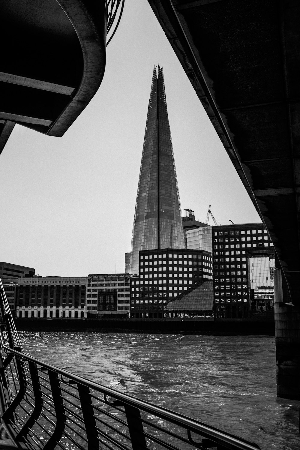 grayscale photo of high rise building near body of water