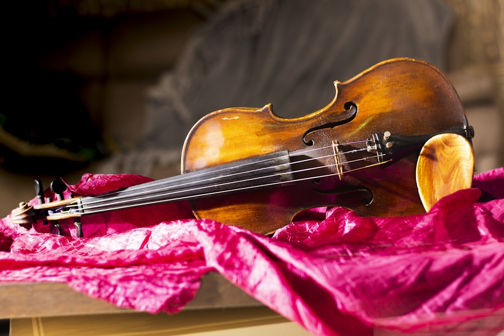 brown violin on red textile