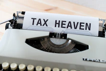 a close up of a typewriter with a tax heaven sign on it