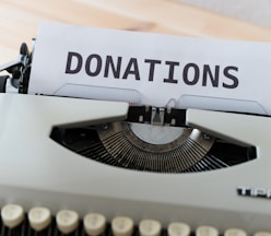 a close up of a typewriter with a donation sign on it