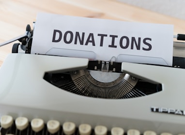 a close up of a typewriter with a donation sign on it