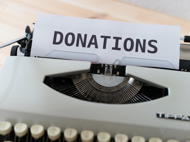 a close up of a typewriter with a donation sign on it