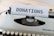 A vintage typewriter with a sheet of paper displaying the word 'DONATIONS' in bold uppercase letters. The typewriter is on a wooden surface with a soft focus on the background.