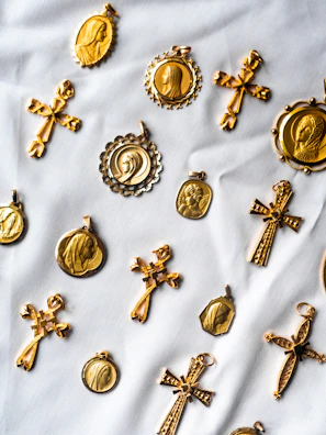 Array of medallions laid out on a wooden table beside hiking boots and a compass.