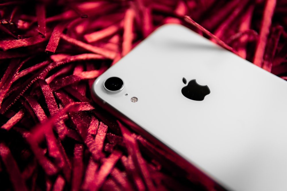 white iphone 5 c on red textile