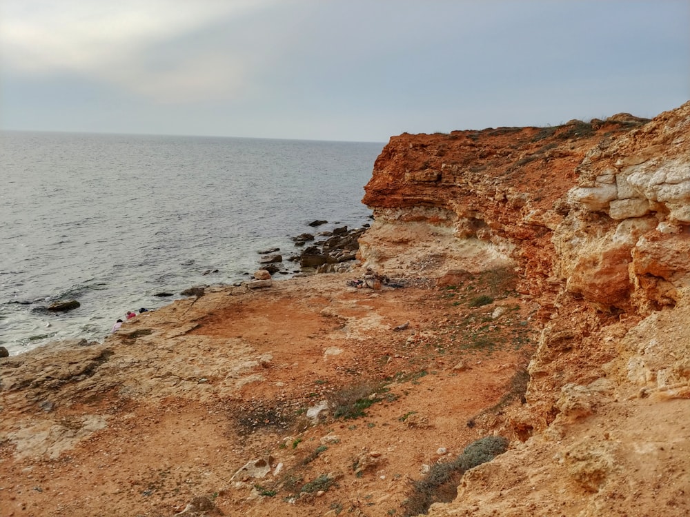 brown rock formation near body of water during daytime