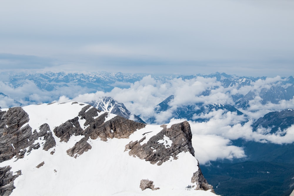 snow covered mountain under white clouds during daytime