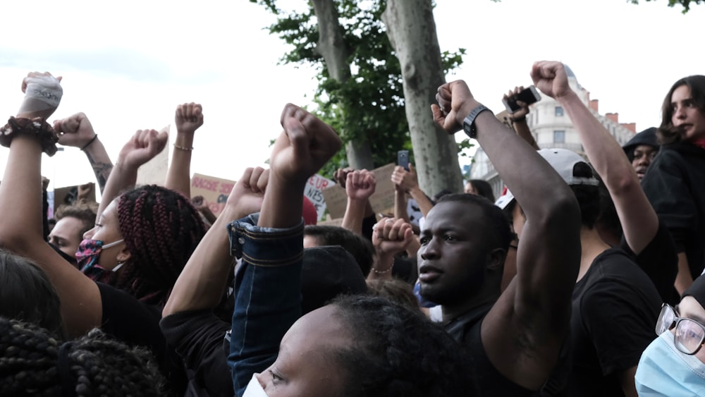 people raising their hands during daytime