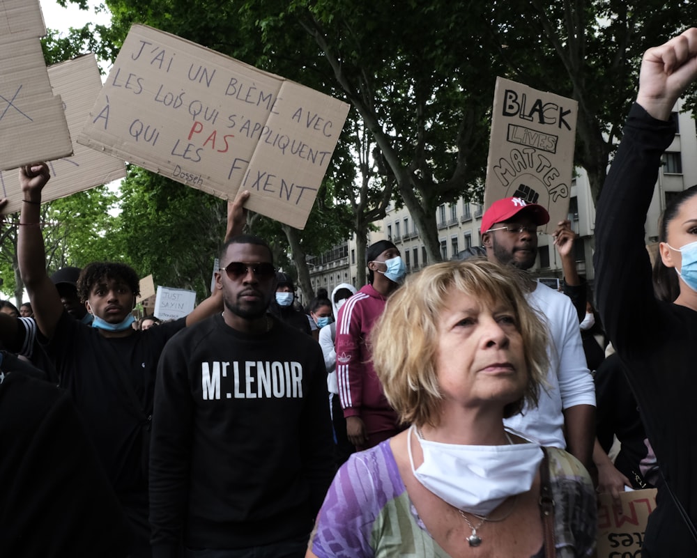 people standing and holding white printer paper during daytime