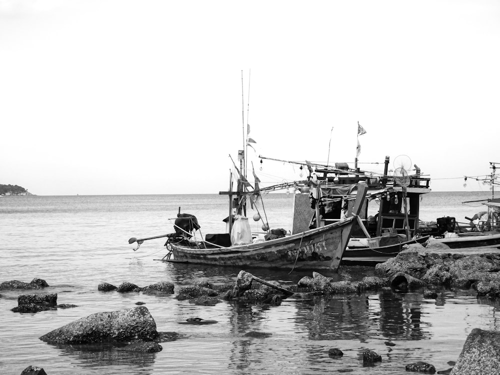 grayscale photo of people riding boat on water