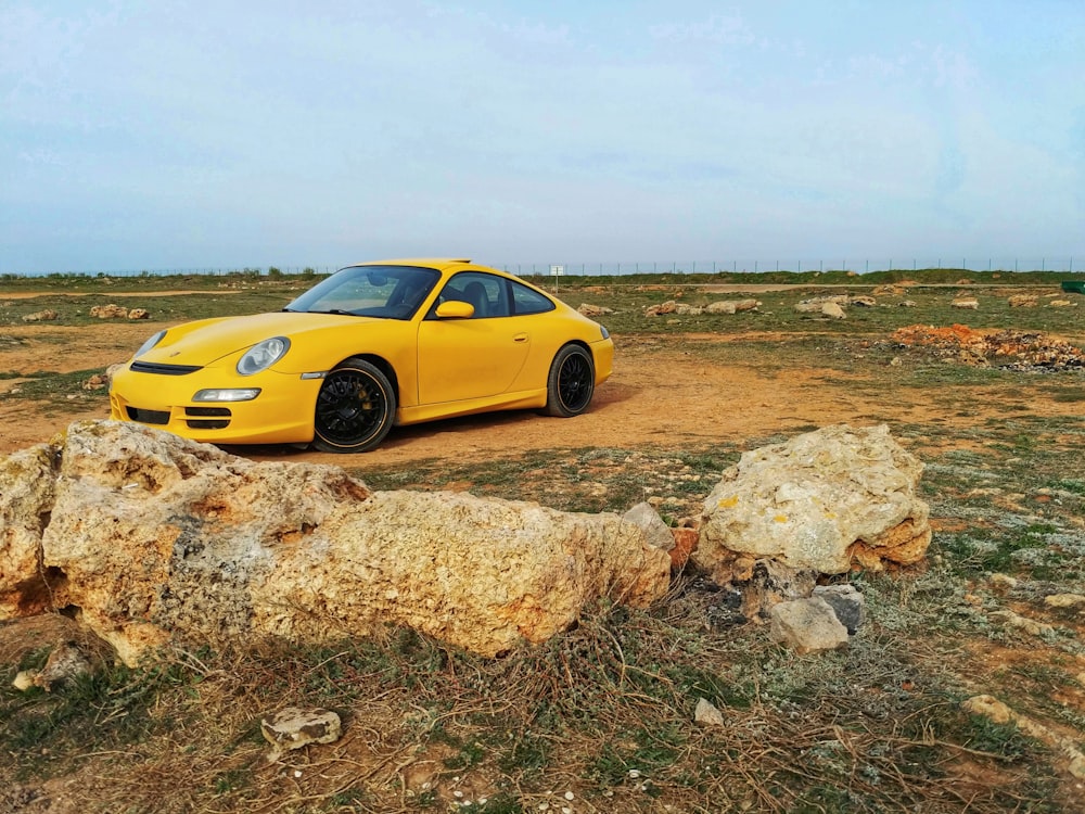 yellow coupe on brown grass field during daytime