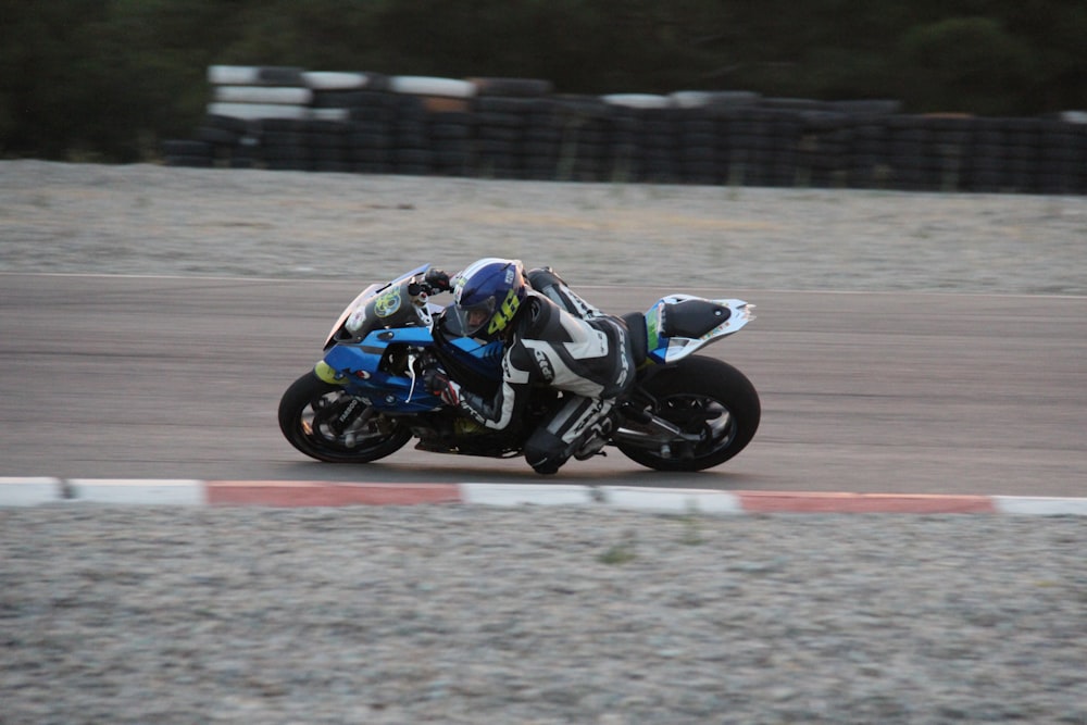 man in black and white motorcycle suit riding on black motorcycle