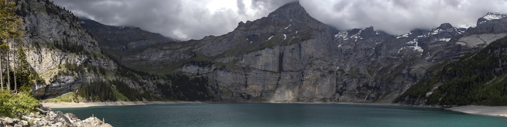 gray rocky mountain beside blue sea under white cloudy sky during daytime