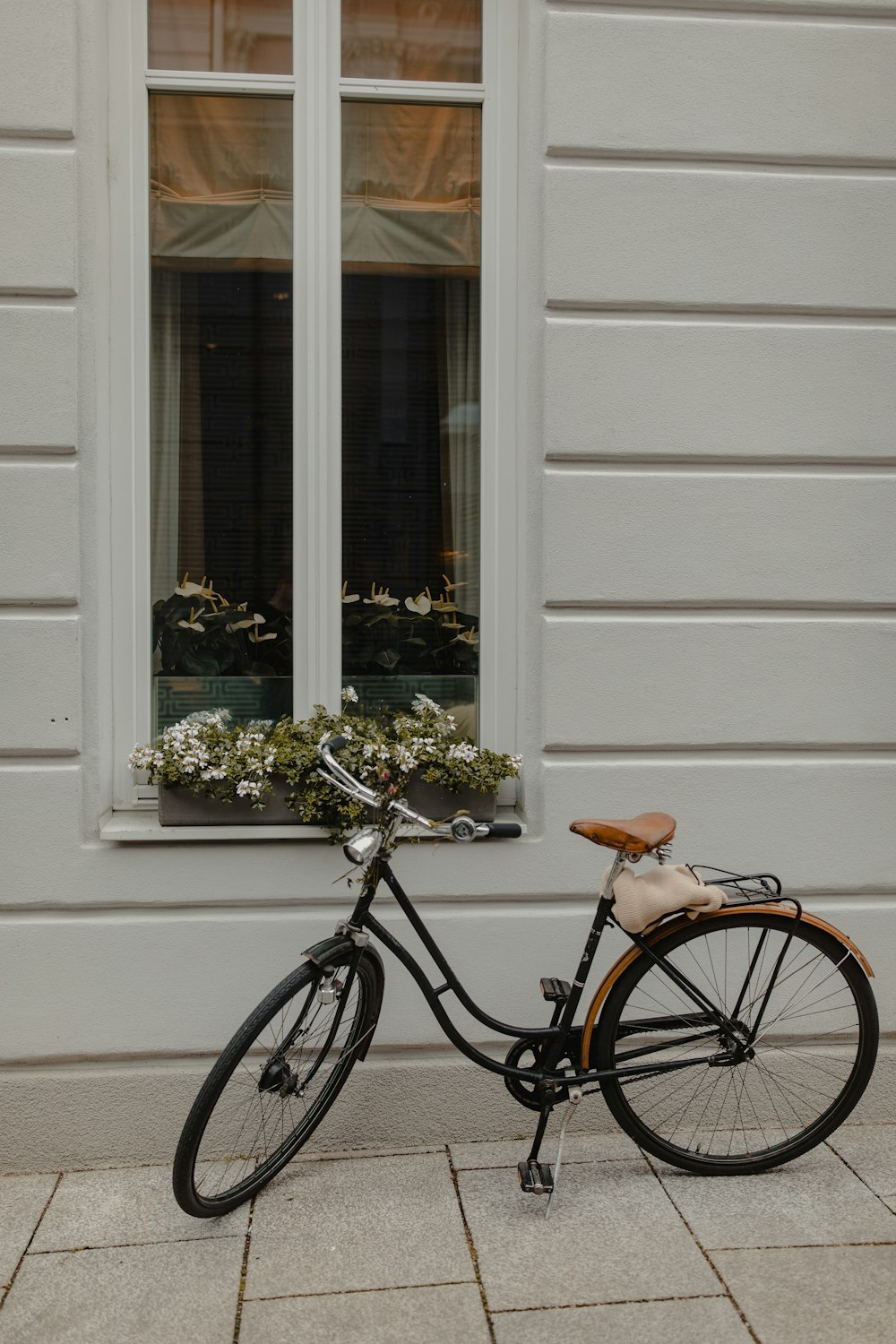 black city bike parked beside white wall