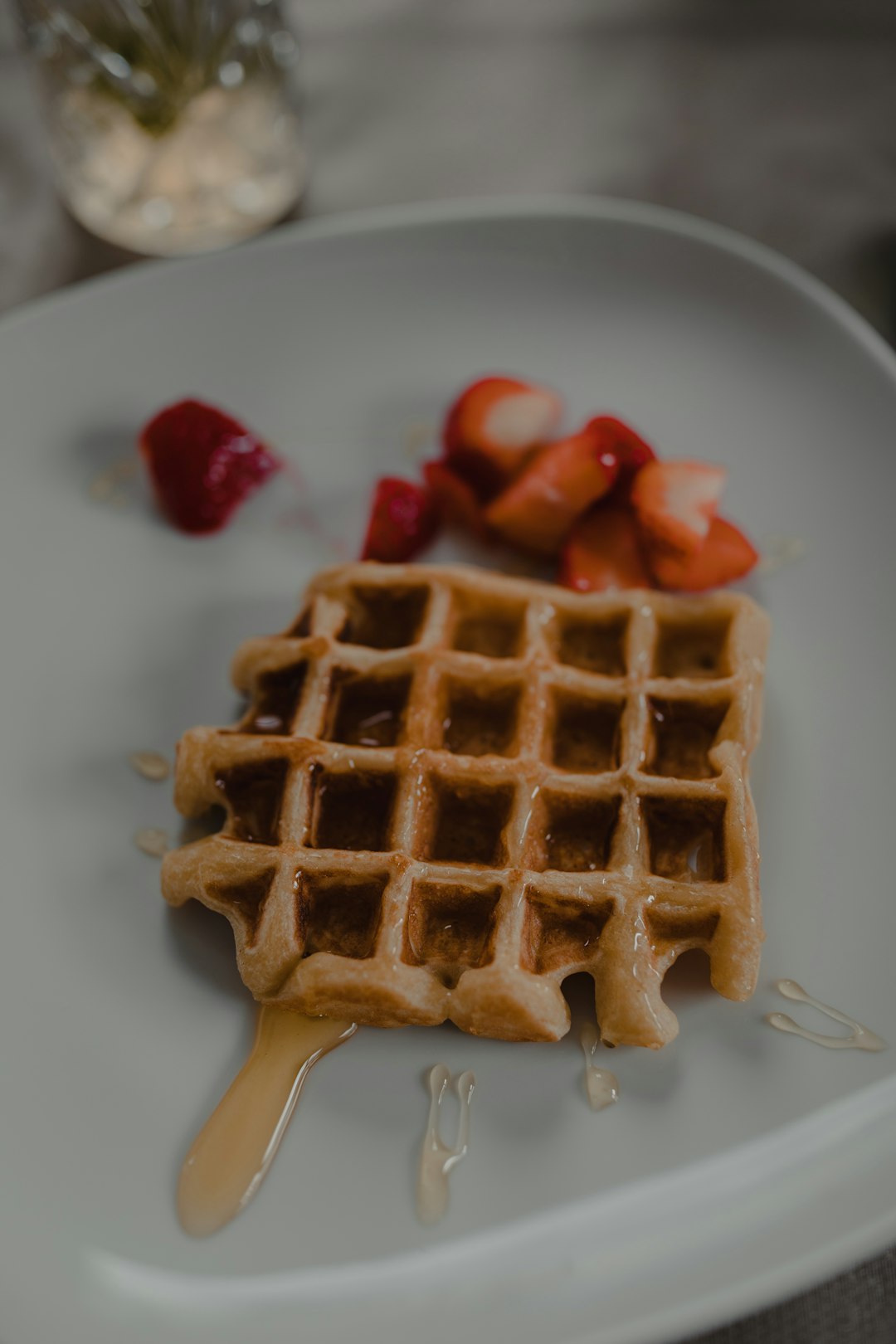 waffle with red syrup on white ceramic plate