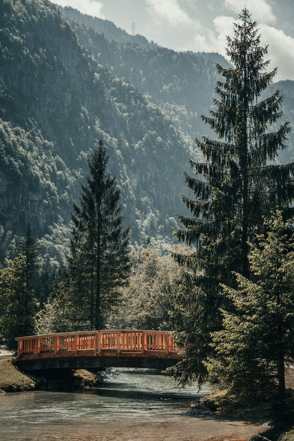 brown wooden bridge near snow covered mountain during daytime