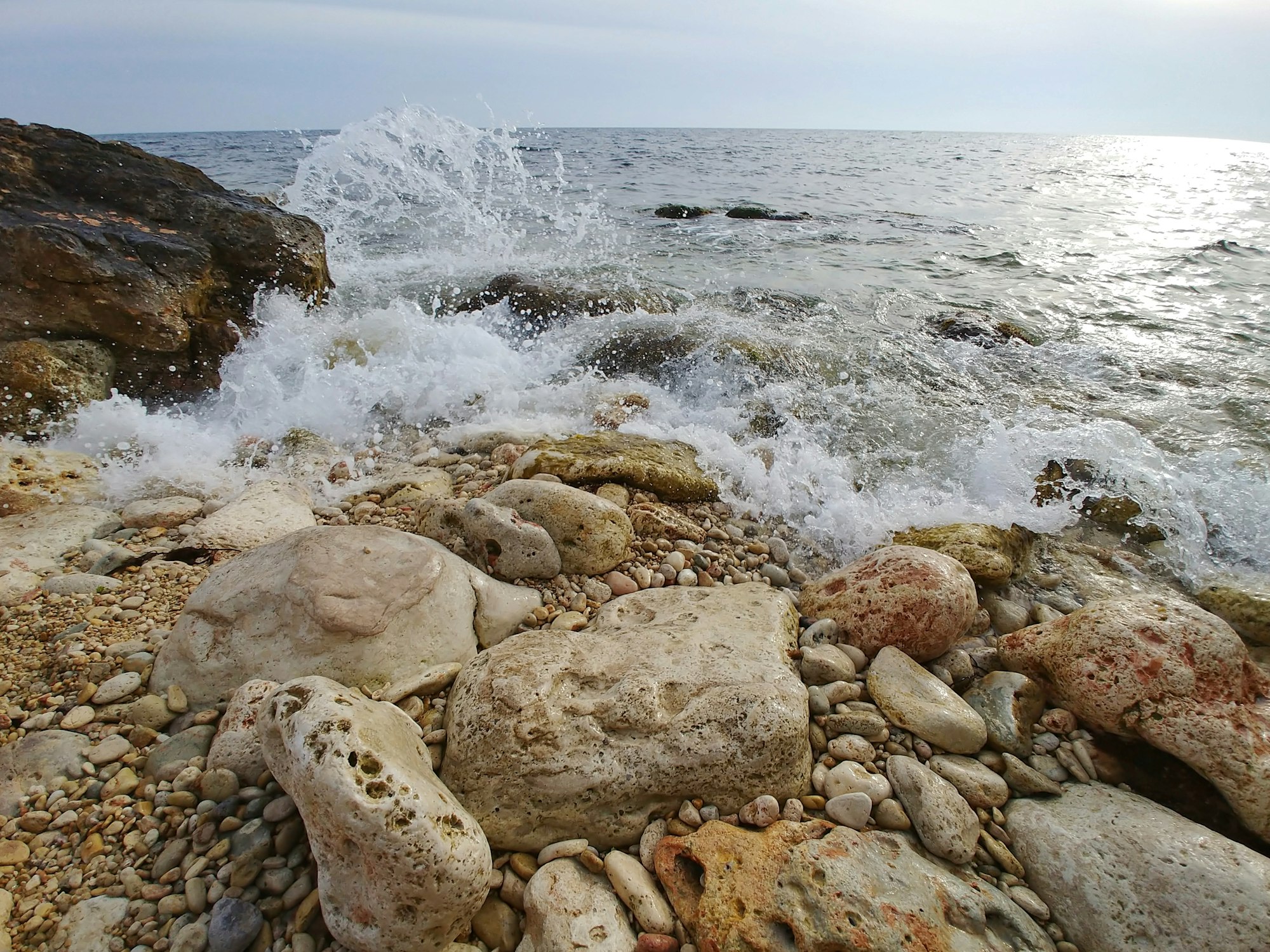 brown and gray rocks near body of water during daytime