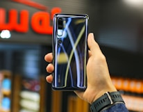 Close-up of hands testing a sleek smartphone in the 123peak store.