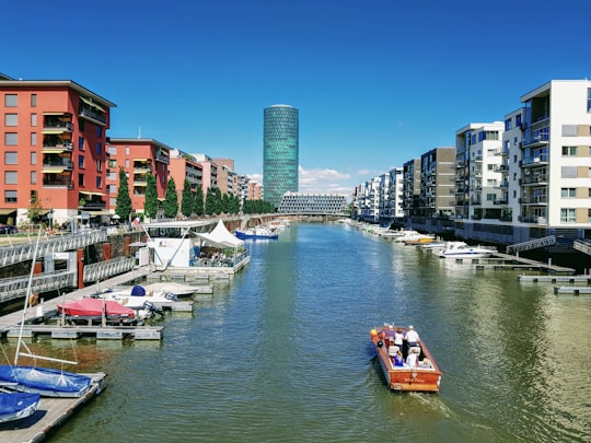 boat on river between buildings during daytime in Frankfurt Germany