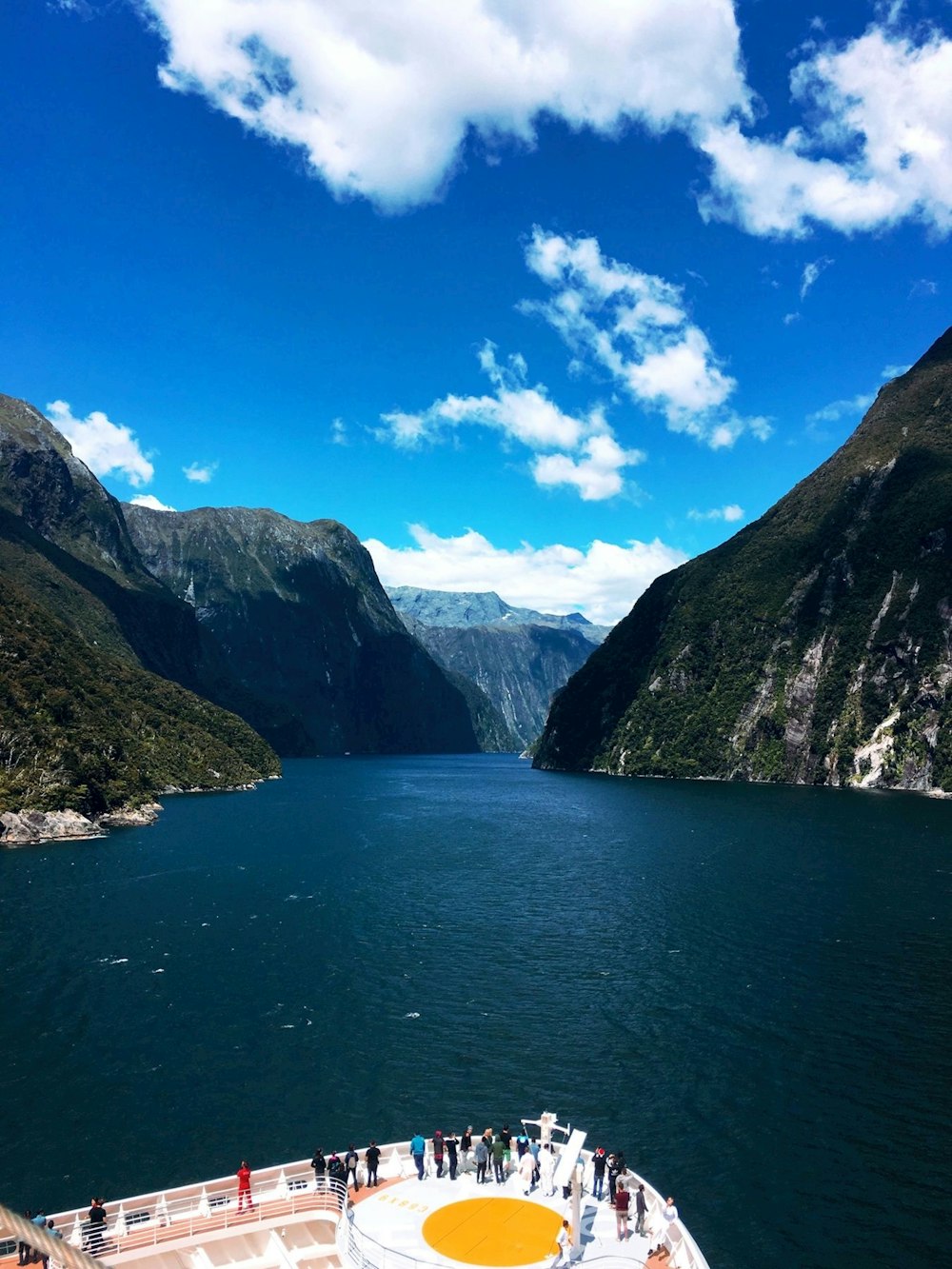 green and brown mountains beside body of water under blue sky during daytime