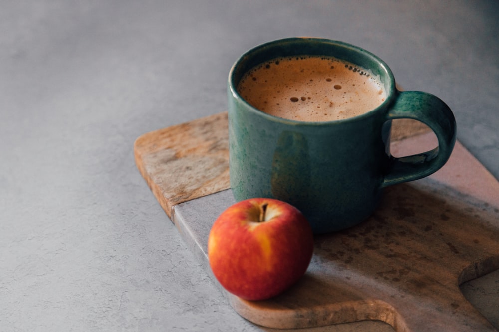 green ceramic mug with brown liquid inside