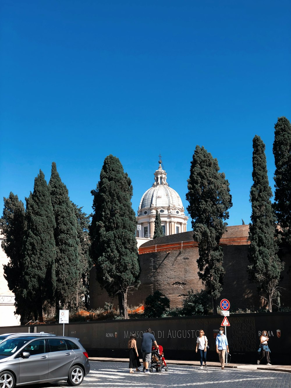 white and brown dome building near green trees under blue sky during daytime