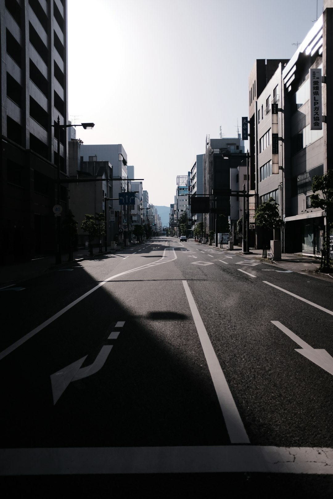 gray concrete road between high rise buildings during daytime