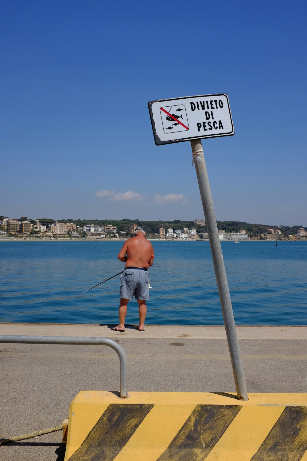 hombre en pantalones cortos azules pescando en el mar durante el día