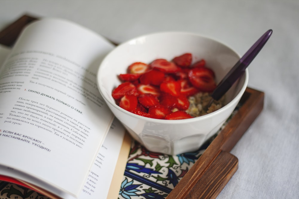 red sliced fruit on white ceramic bowl