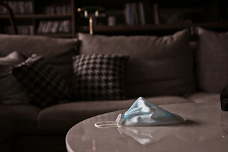 A sleek photon therapy mask resting on a soft white towel with gentle ambient lighting highlighting its smooth surface.