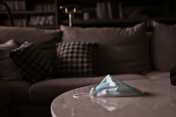 A sleek photon therapy mask resting on a soft white towel with gentle ambient lighting highlighting its smooth surface.