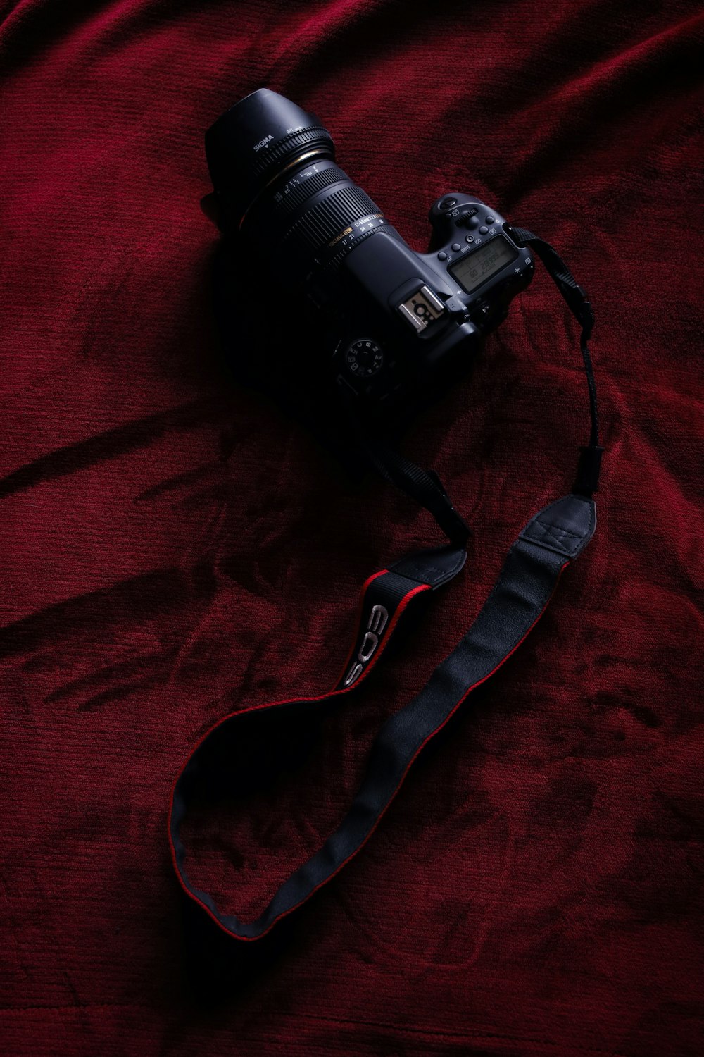black dslr camera on red textile